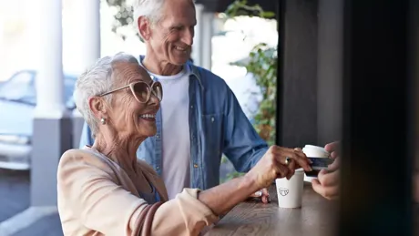 Senior Couple Ordering Coffee To Go At Street Bakery