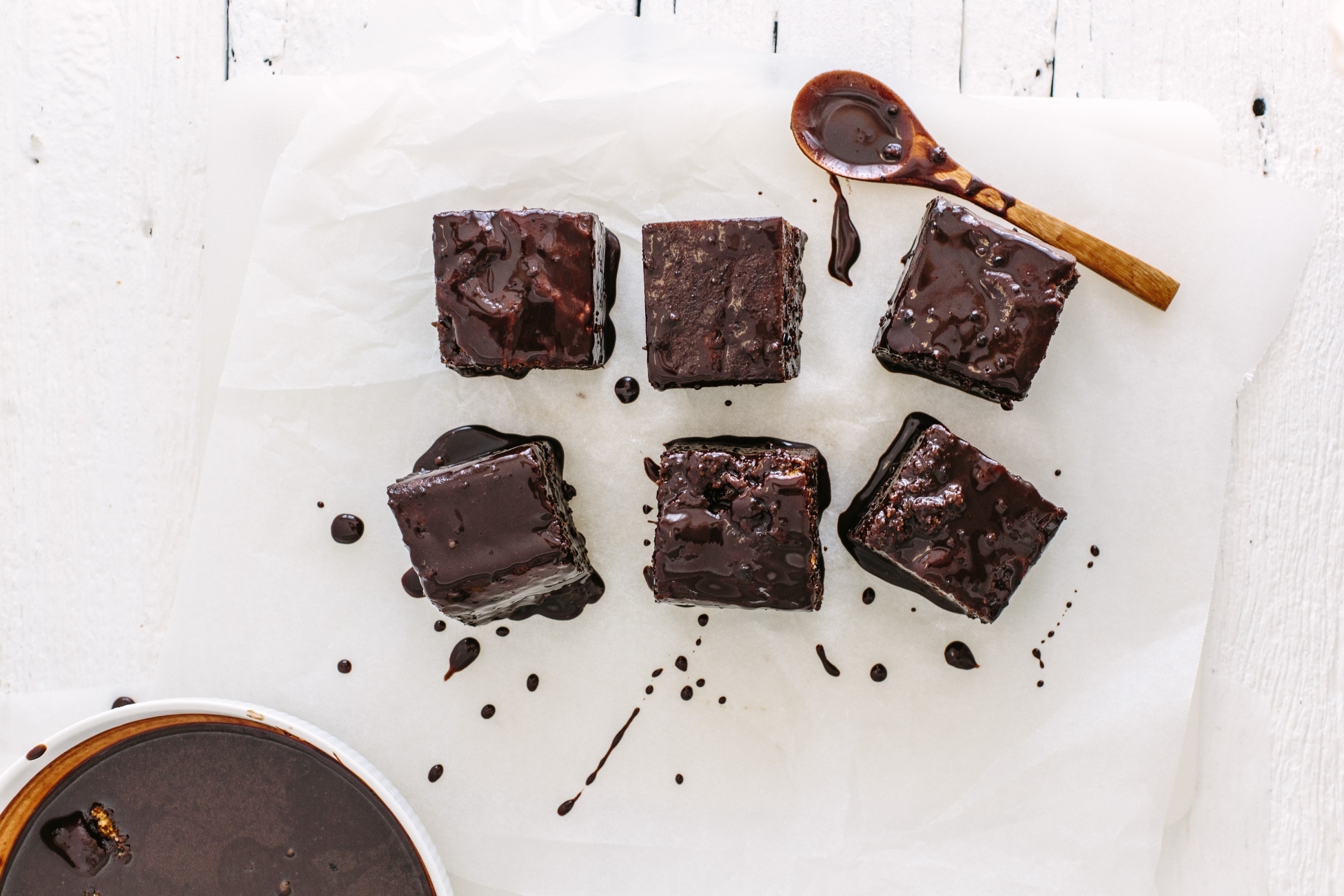 Birds-eye view of Lamingtons, a chocolate cake, next to a wooden spoon