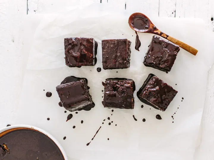 Birds-eye view of Lamingtons, a chocolate cake, next to a wooden spoon