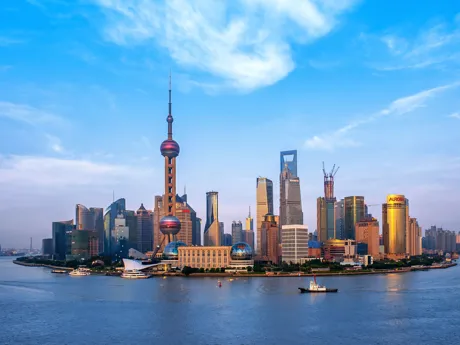 A skyline of Shanghai, made up of skyscrapers and the striking Pearl TV Tower with a tall spire.