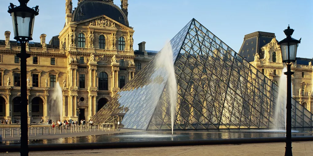Image of the Louvre taken from behind water fountain