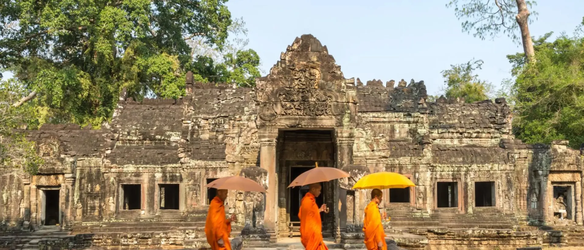 Three Monks With Umbrella Walking Inside A Temple