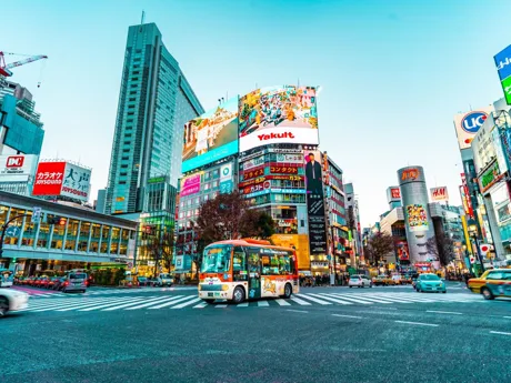 Colorful bus in foreground of Street City Center scene Tokyo Japan