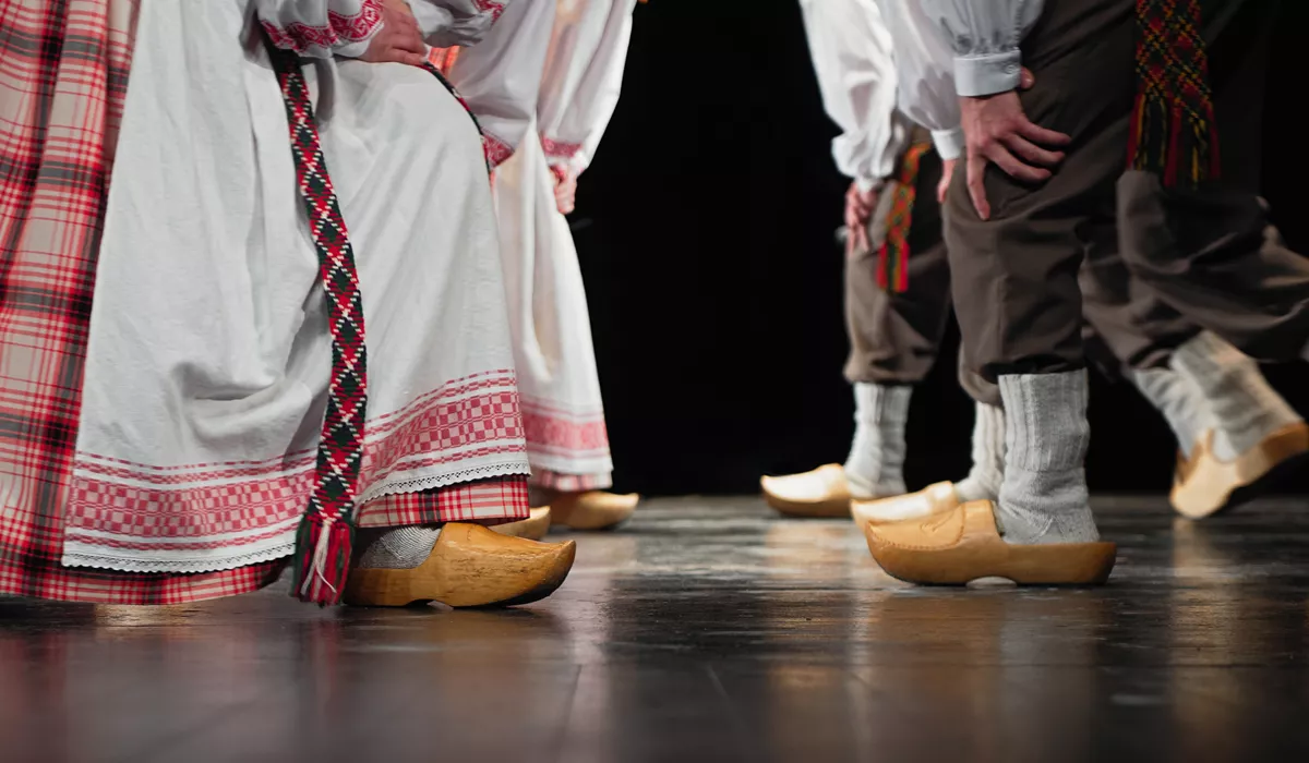 A group of people dancing in traditional clothes and wooden clogs