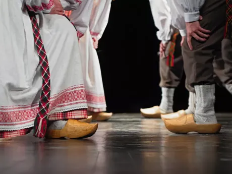 A group of people dancing in traditional clothes and wooden clogs