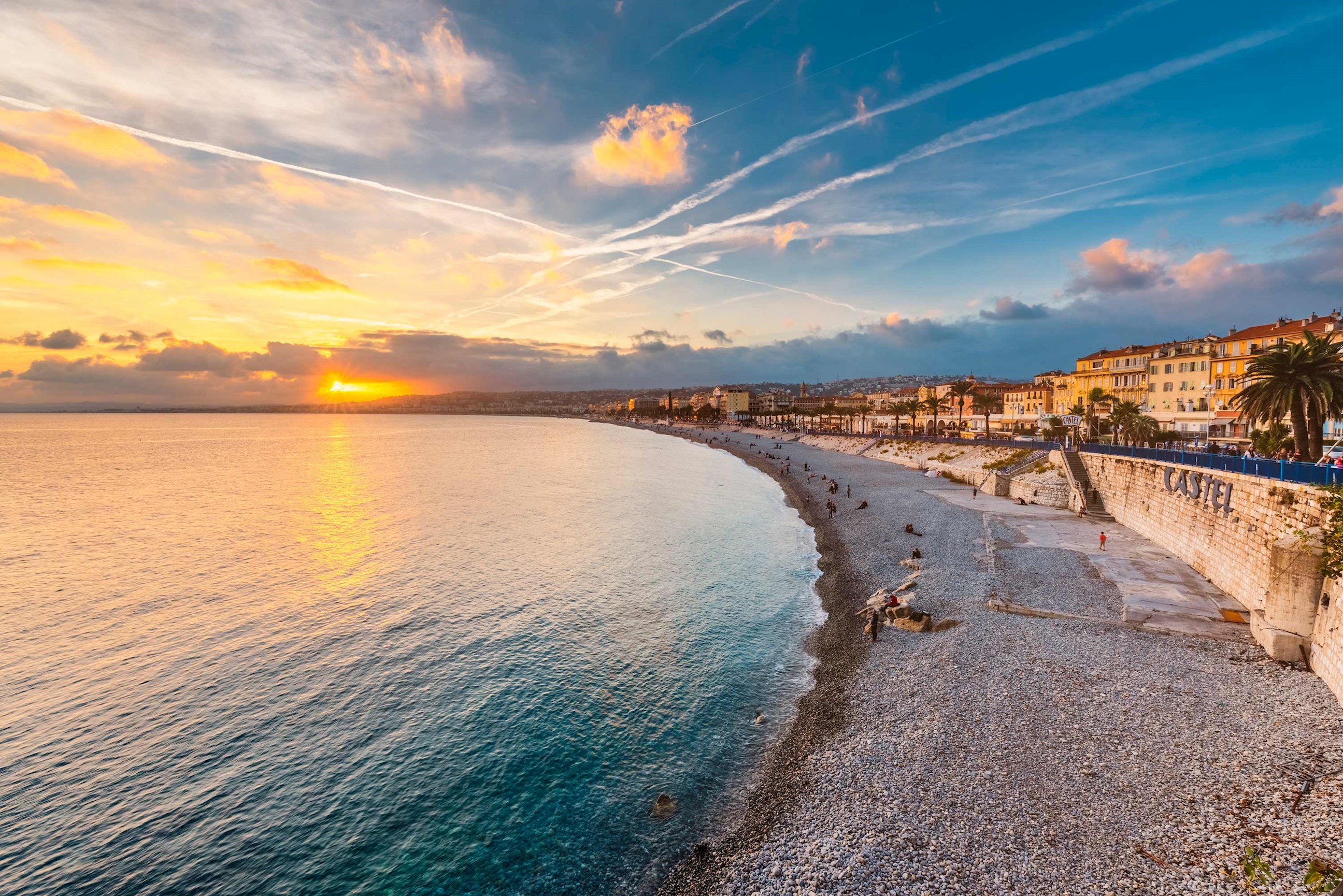 A coastal town with palm trees along a beach in Nice, France