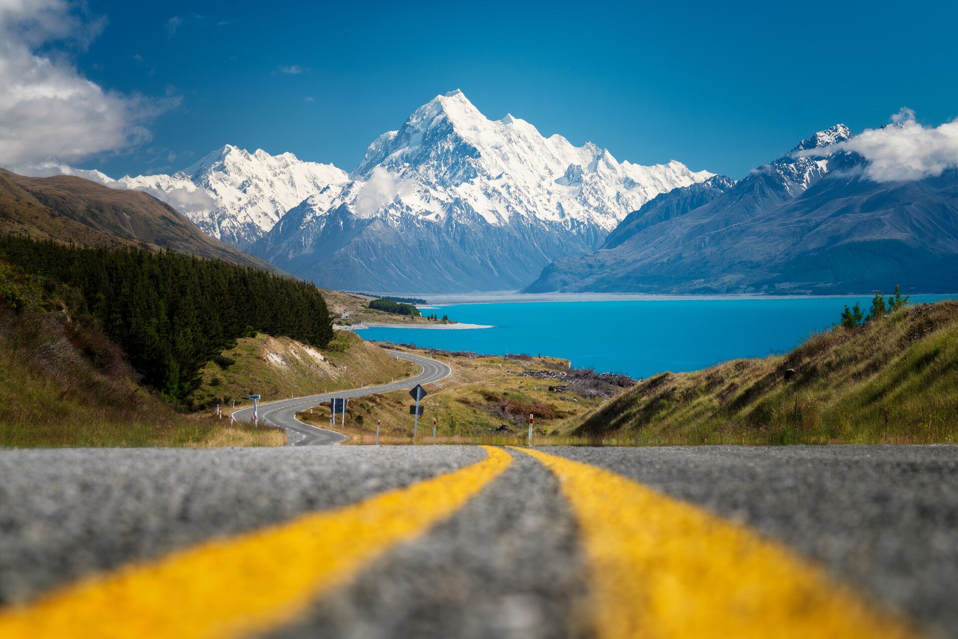 Low-angle POV shot of a road winding down towards a mountain in New Zealand