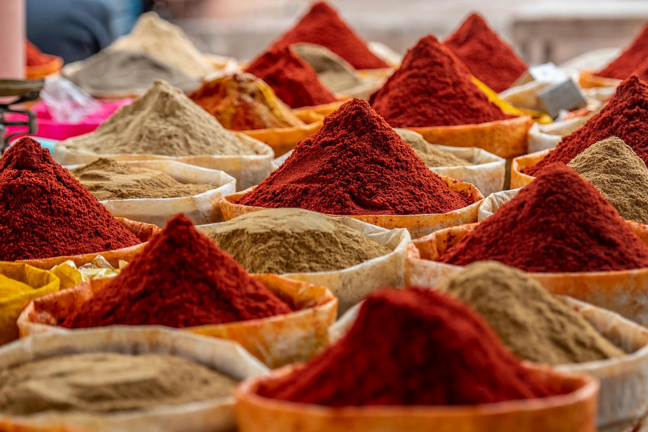 Colourful piles of ground spices displayed in sacks