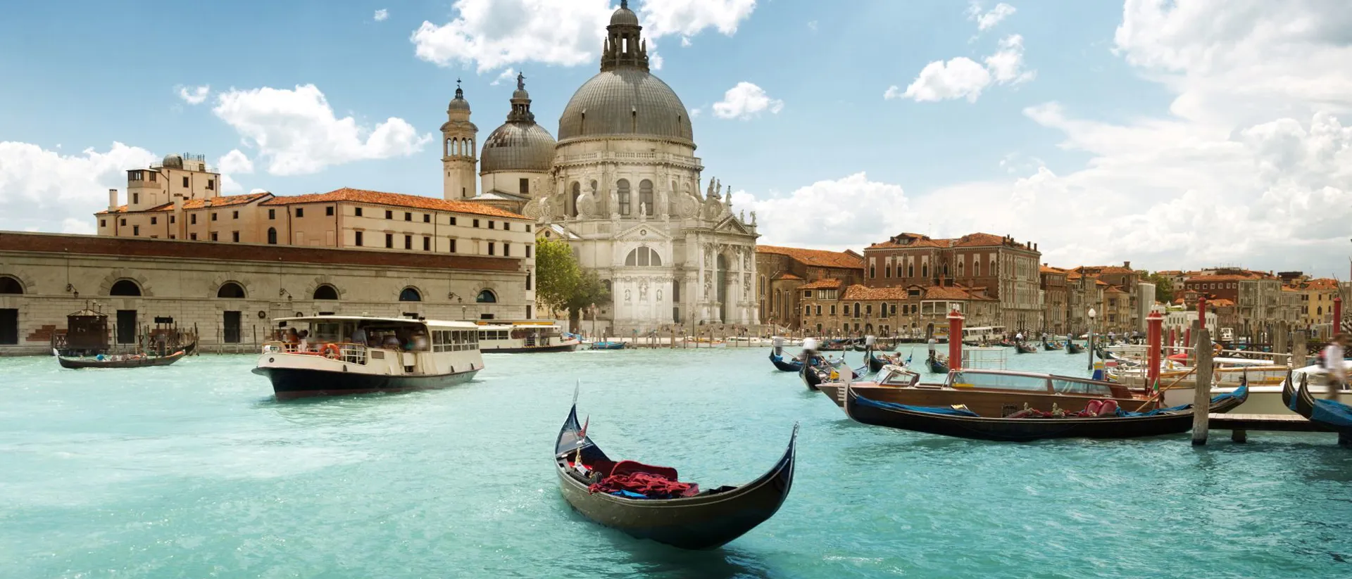 Buildings, boats and gondolas in the middle of a Venice canal