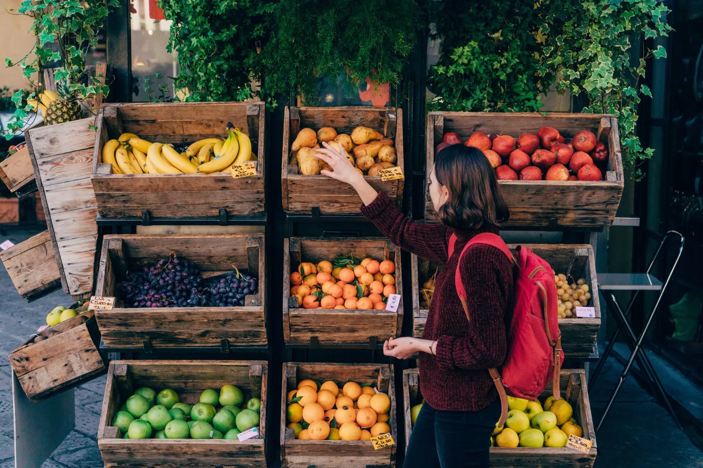 Lady picking fruit at a fruit stall