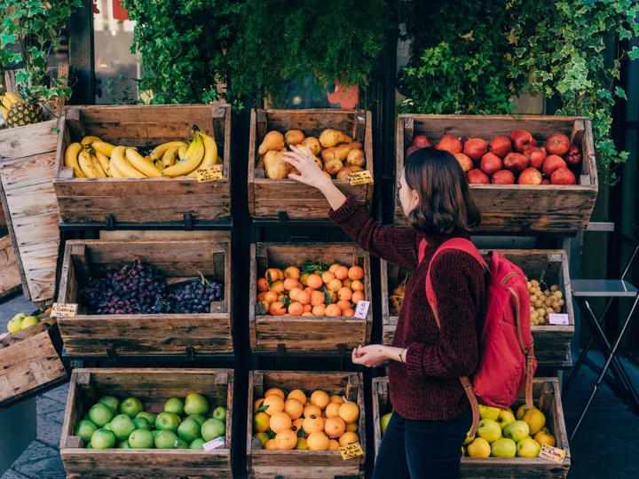 Lady picking fruit at a fruit stall