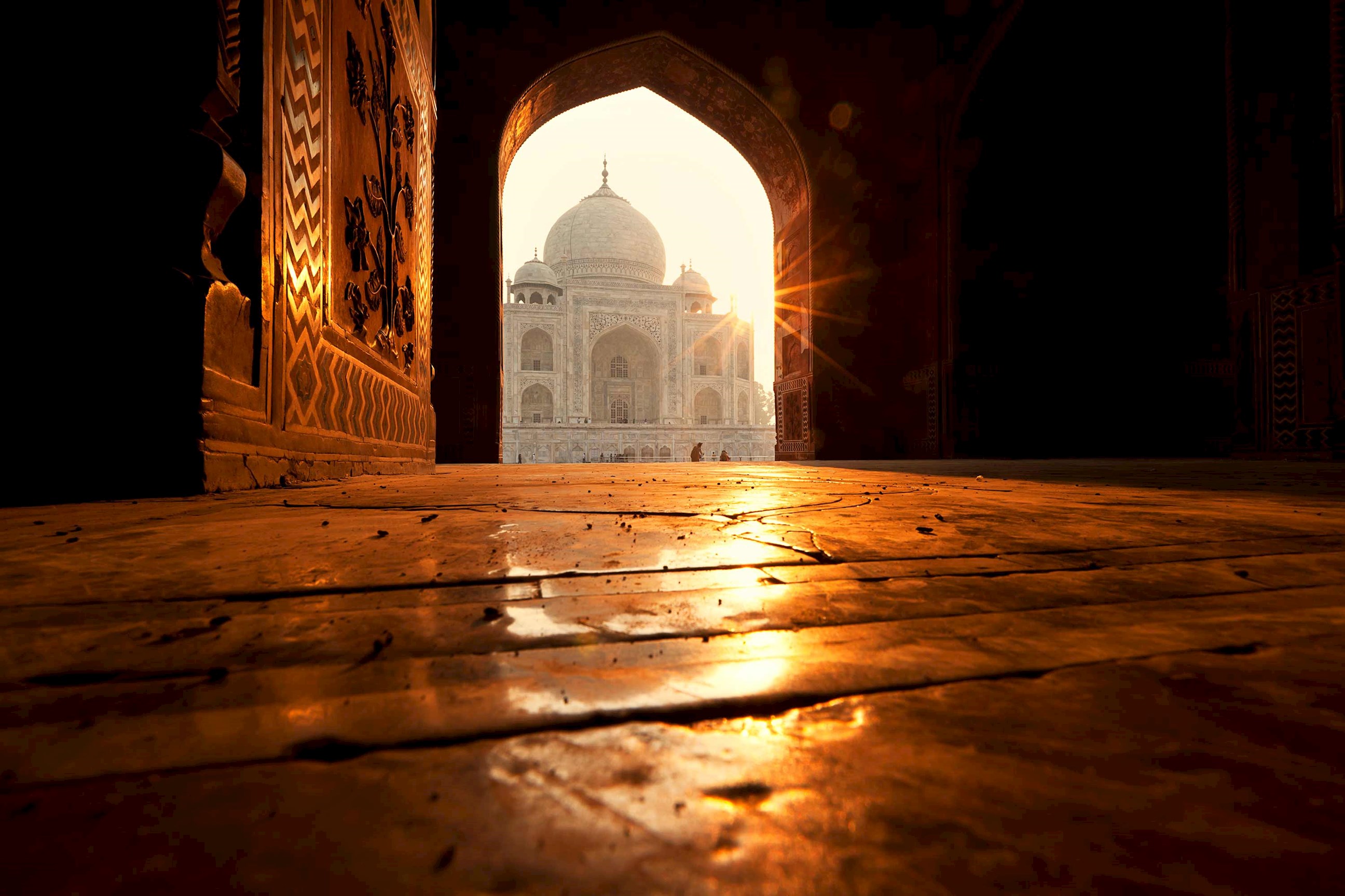 Taj Mahal seen through open archway at sunrise in Agra, India