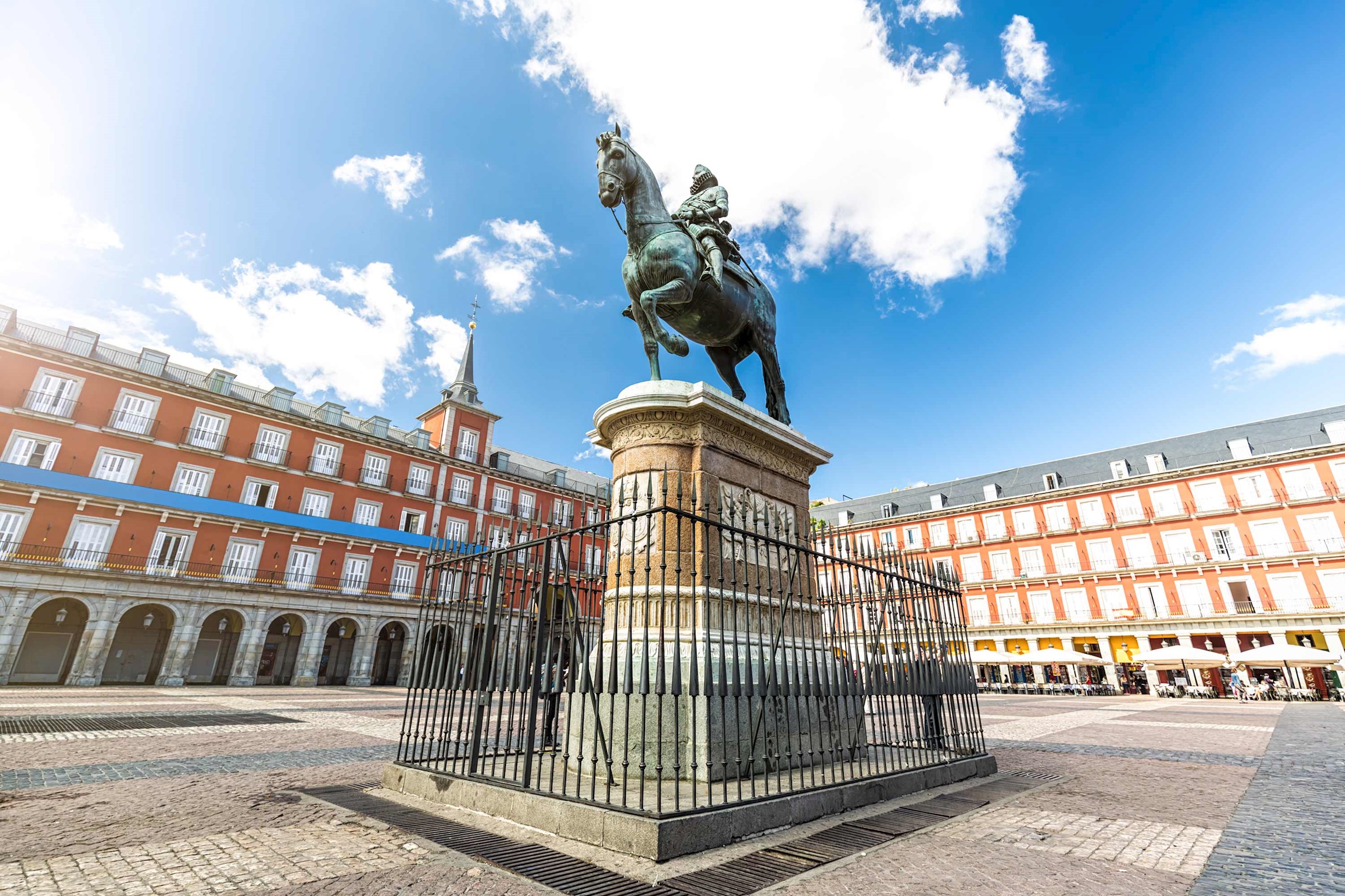 A statue in open square with surrounding architecture in Madrid, Spain