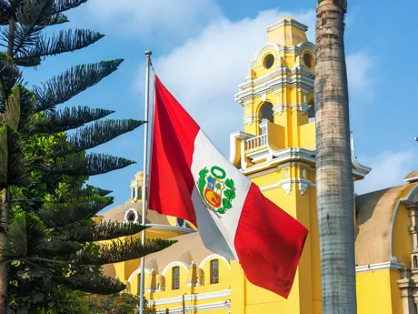 Monastery Of San Francisco with a Peruvian flag in front of it in Lima, Peru