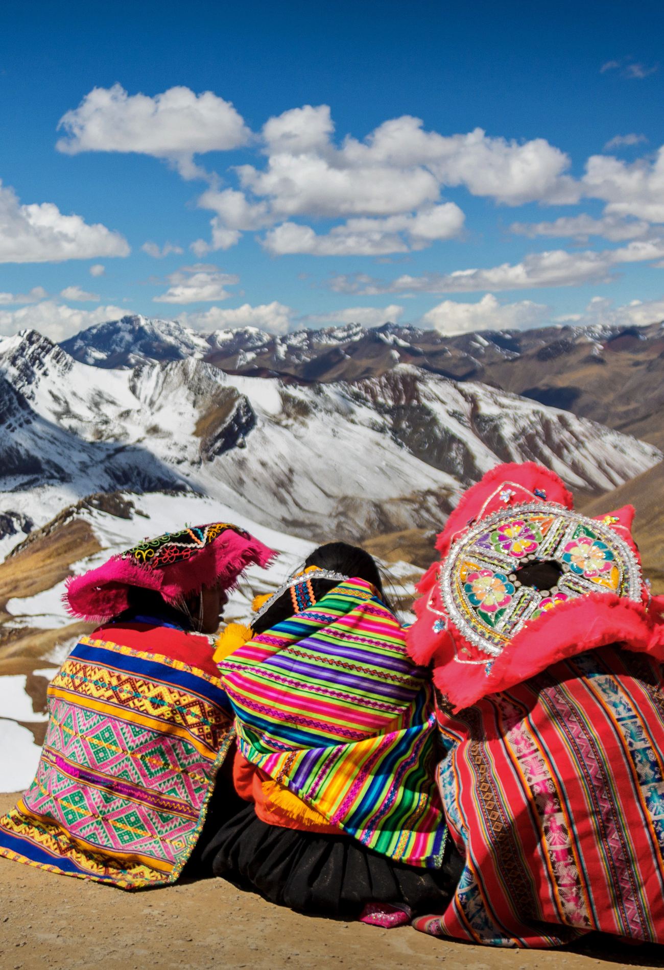 A group of people sitting on top of a snow covered mountain in Peru