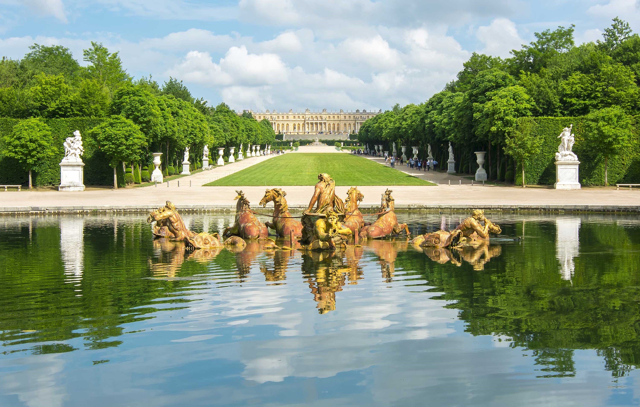 Fountain of Apollo at Versailles with chariot sculpture and tree-lined lawn