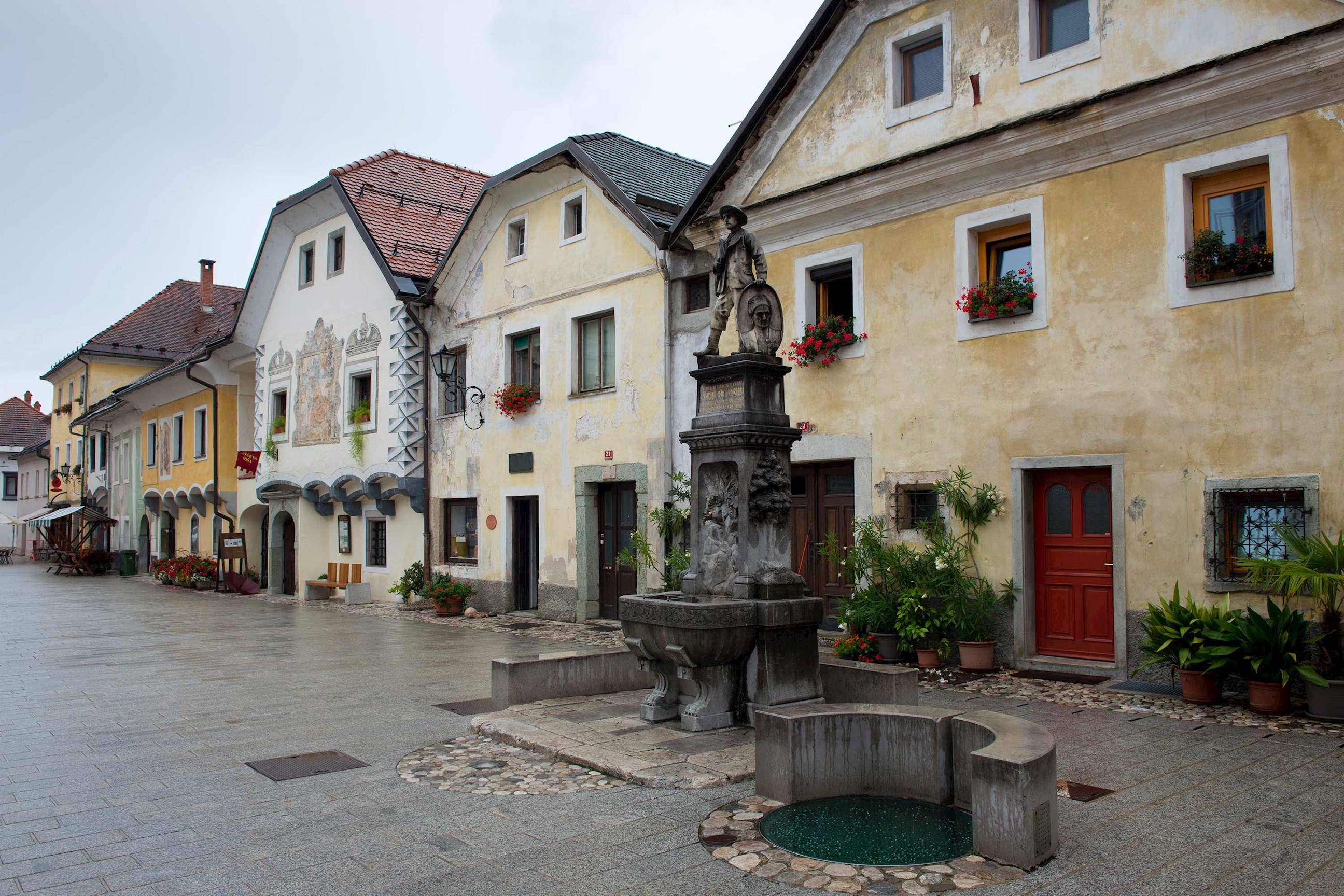 Radovljica town square with colourful houses, flower boxes and stone fountain in in Slovenia 