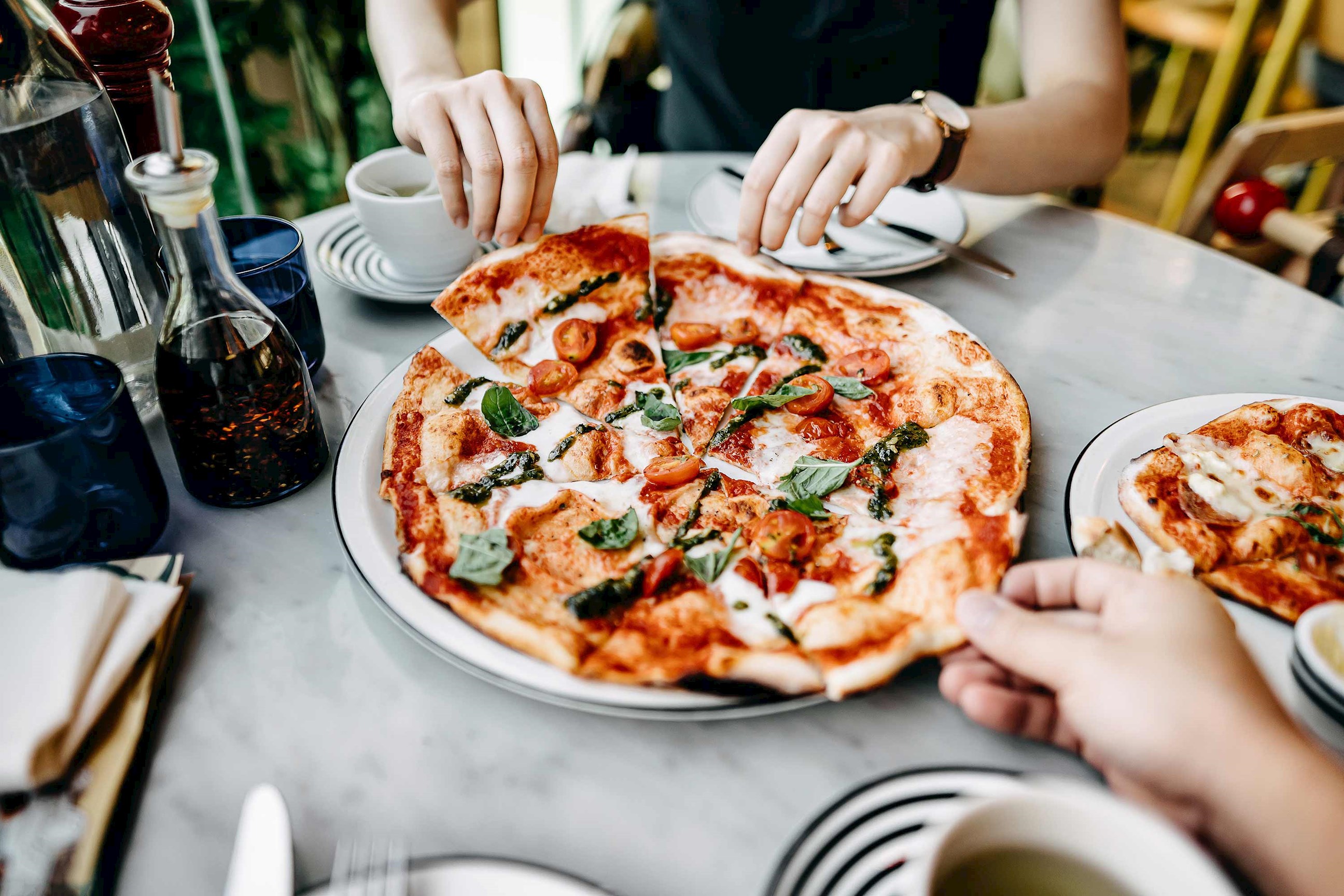A close view of a person eating pizza on a dining table 