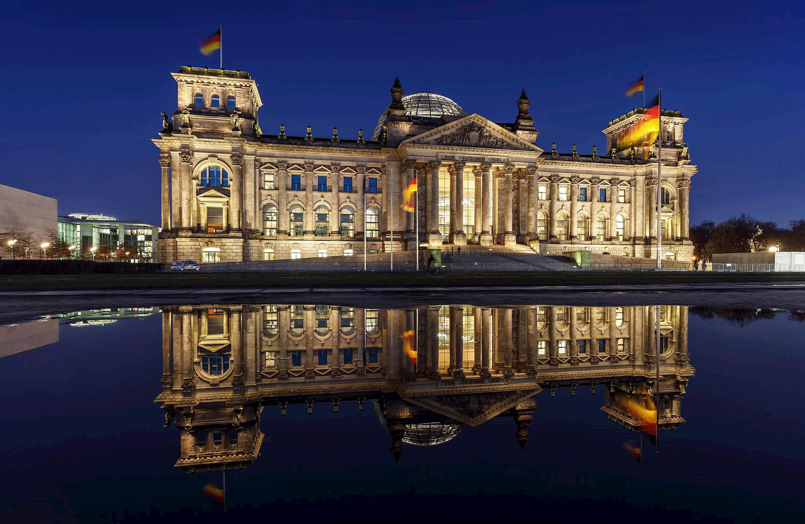 The Reichstag illuminated at night with reflection in water in Berlin, Germany