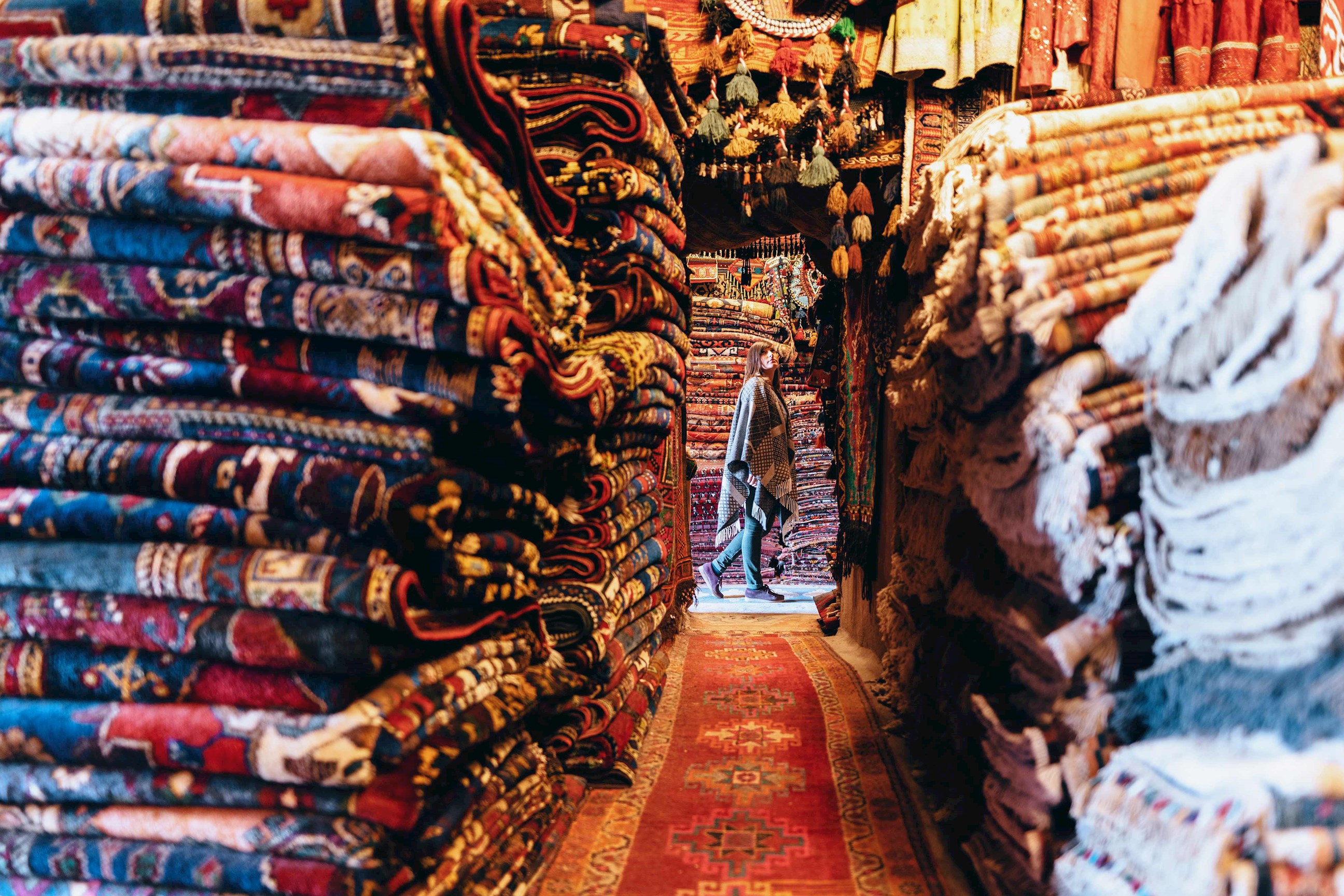 Traveller walking in a colourful carpet market