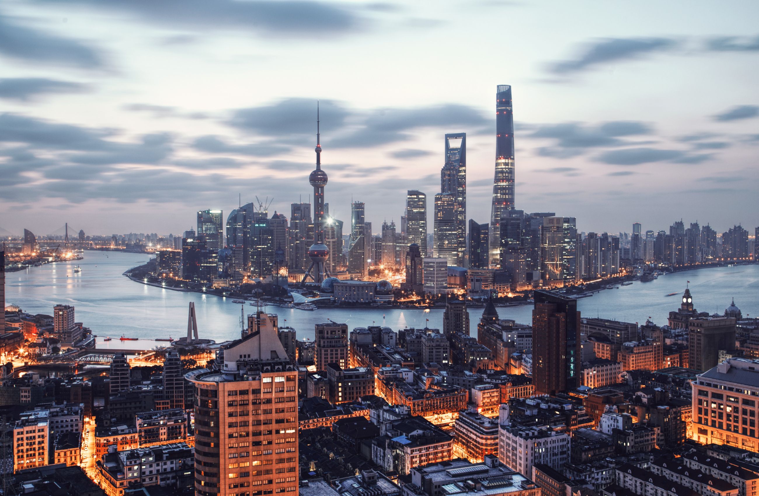 The skyline of Shanghai in China, dominated by tall skyscrapers and with the Huangpu River running through the centre of the picture.