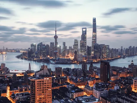 The skyline of Shanghai in China, dominated by tall skyscrapers and with the Huangpu River running through the centre of the picture.