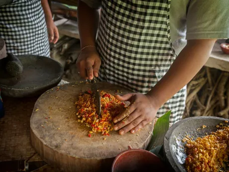Someone cutting red chillies on a wooden block, Ubud Market Cooking Class Bali Indonesia