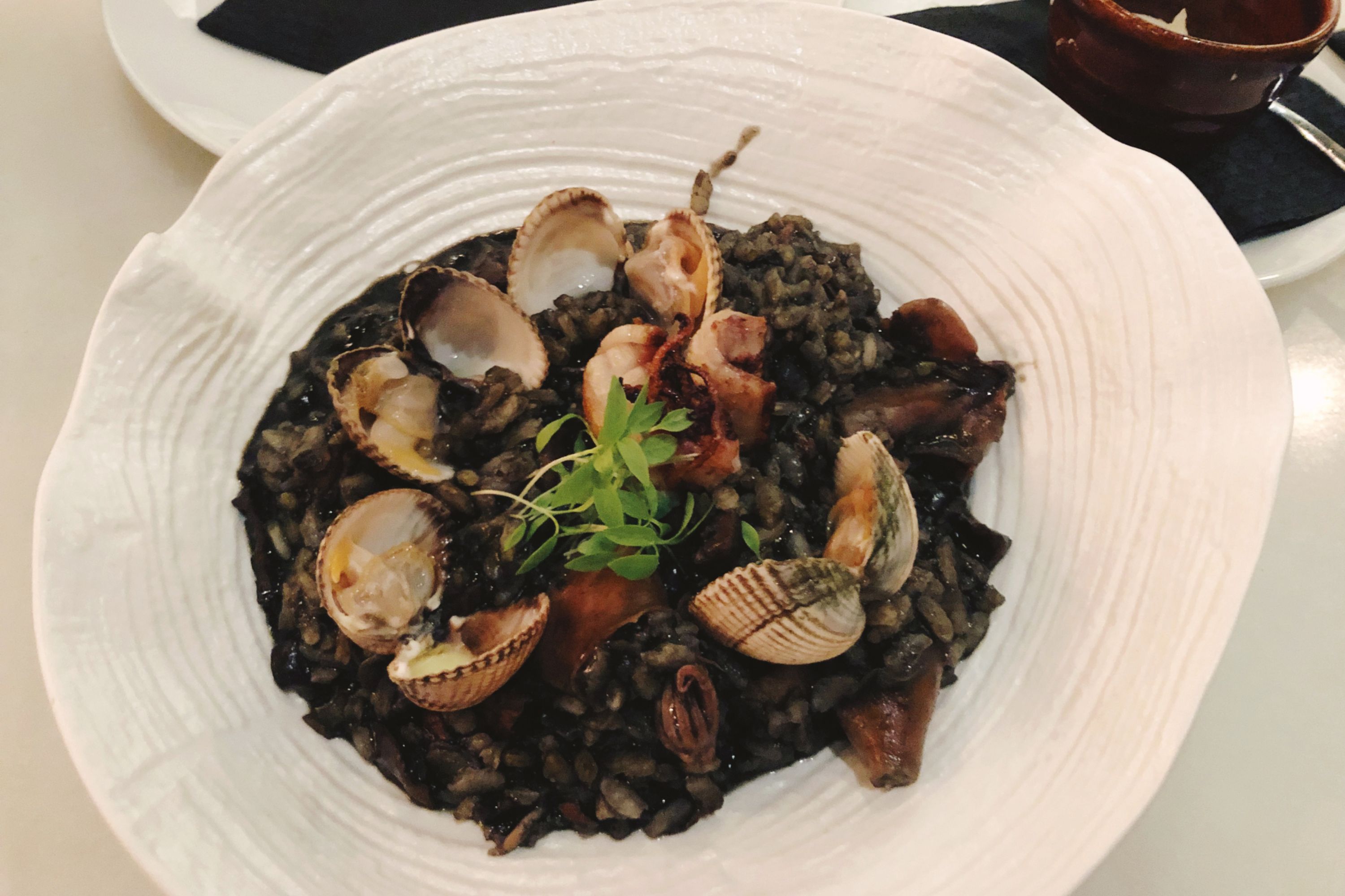 A smart dish of black risotto with shellfish included, a traditional dish from Croatia.