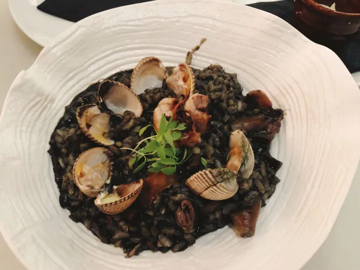 A smart dish of black risotto with shellfish included, a traditional dish from Croatia.