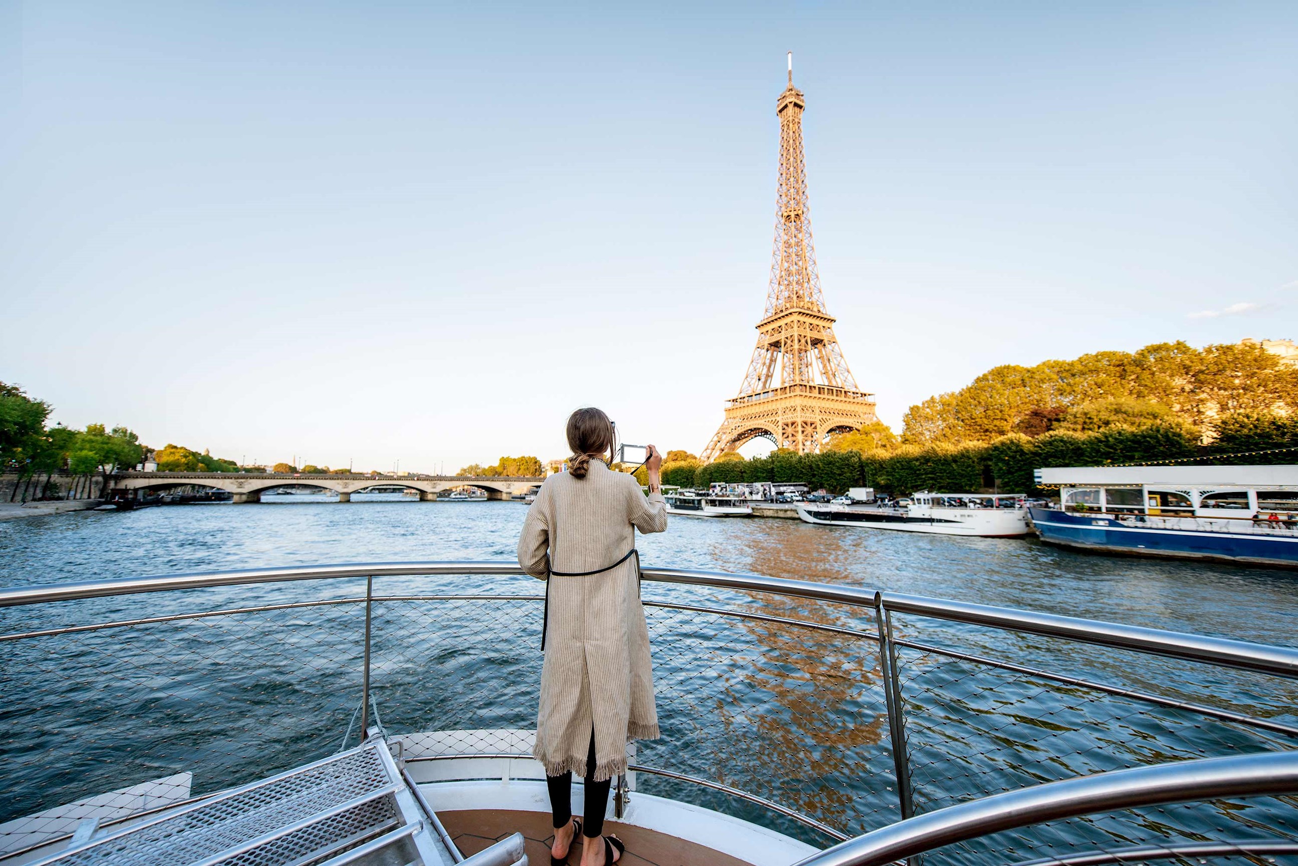 A person on a boat against the Eiffel Tower on a sunny day in Paris, France
