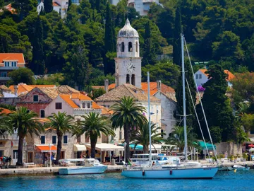 Cavtat harbour with boats, historic buildings and greenery in Croatia