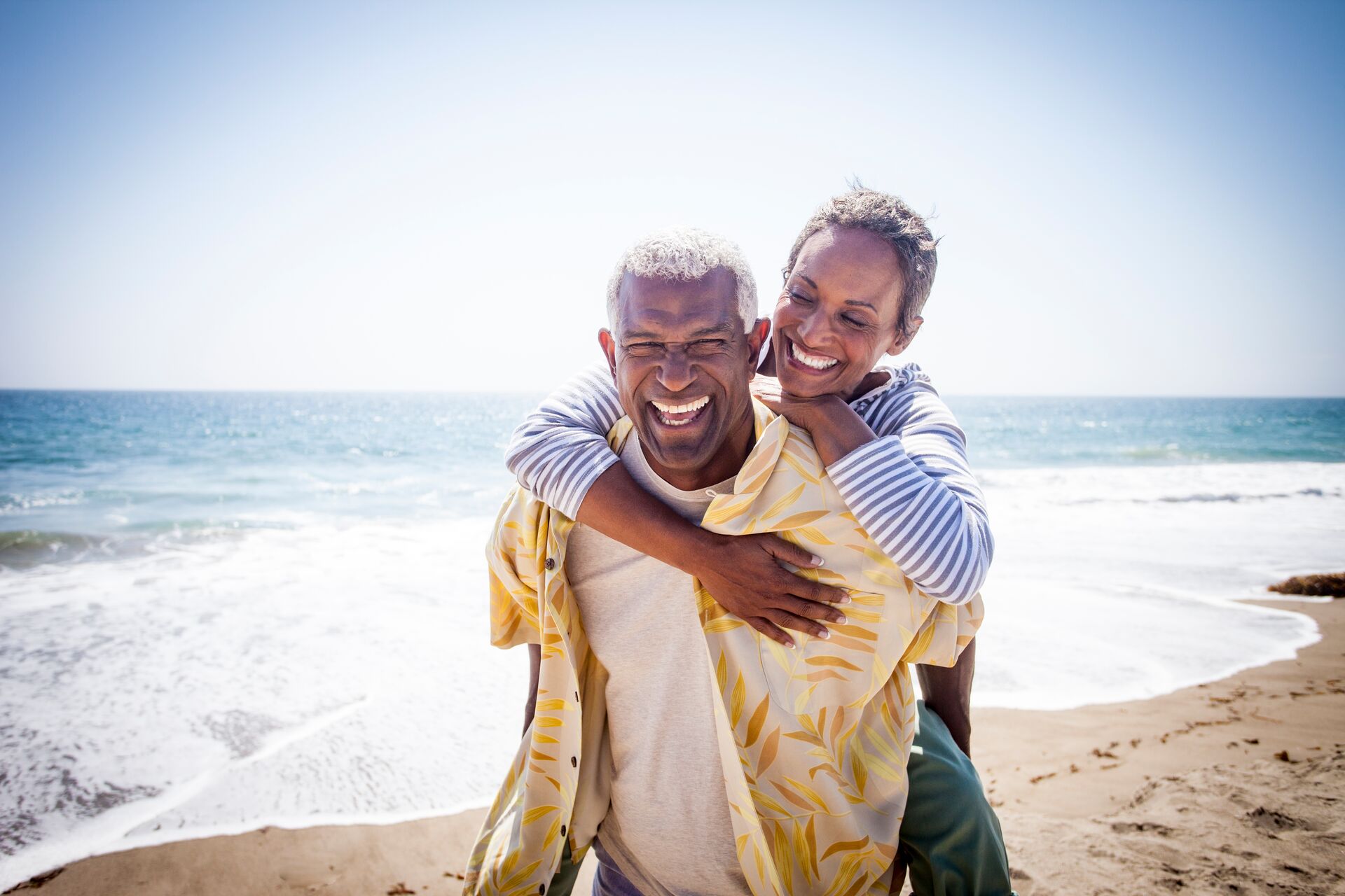 large-black-couple-piggyback-on-beach-802107542.jpg