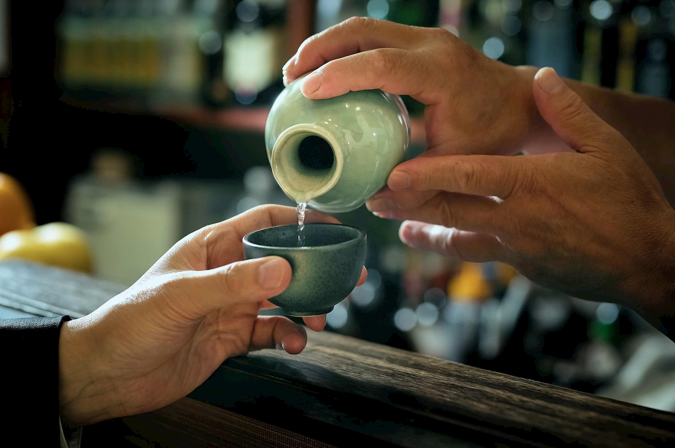 Close-up of sake being poured into traditional ceramic cup