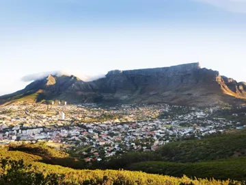 Expansive city view of a flat mountain by green hills in Cape Town