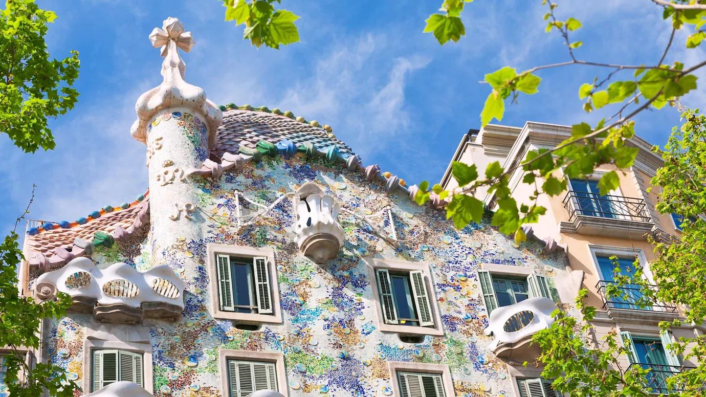 Floral pattern building with curved balconies under blue sky in Barcelona, Spain
