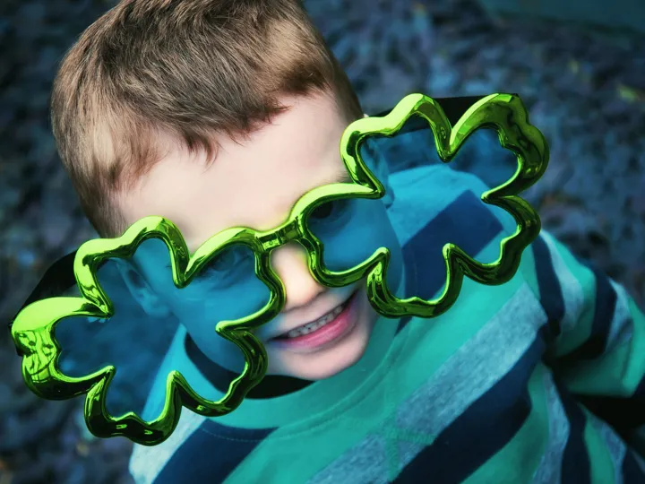 Child wearing giant Shamrock glasses