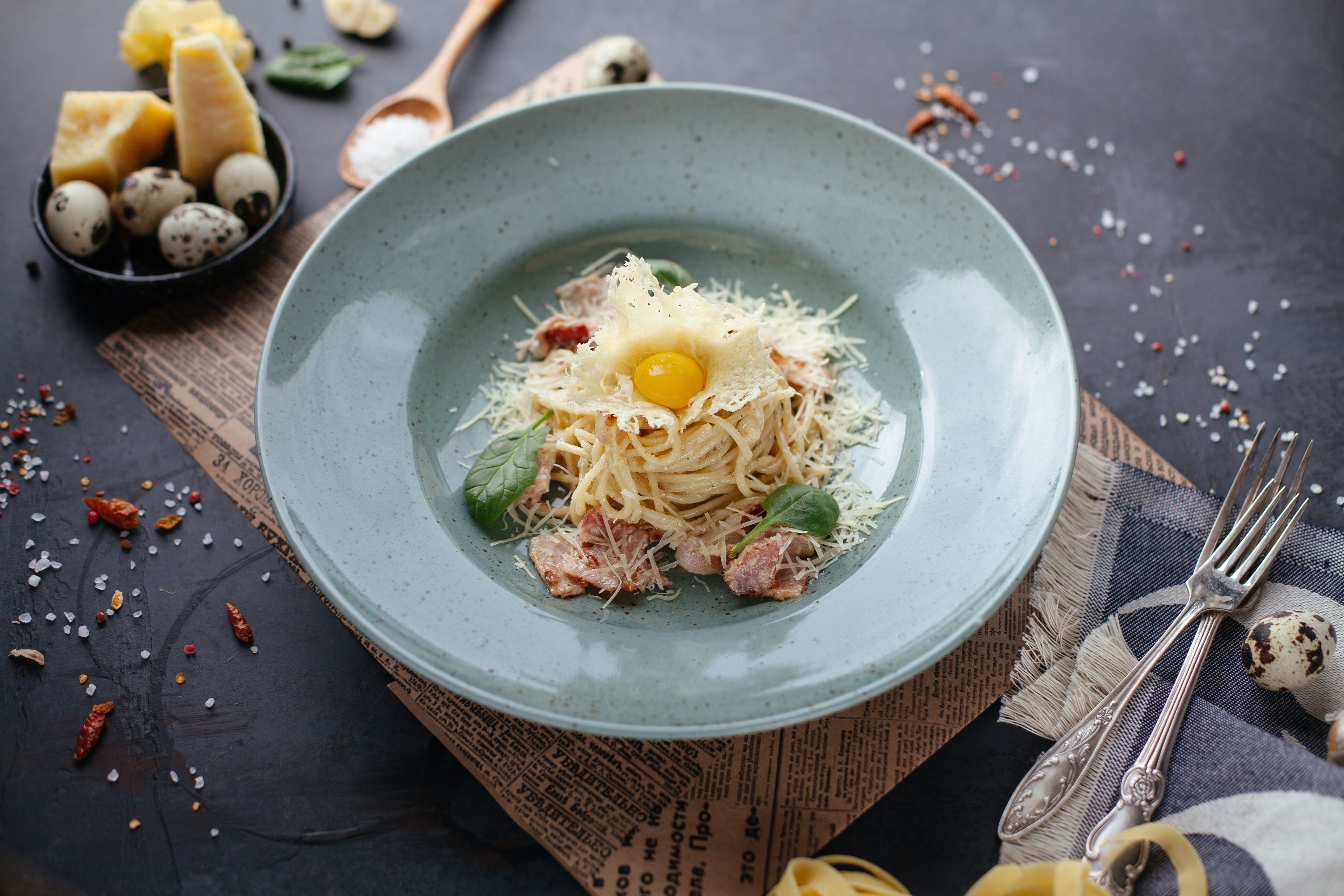 A smart bowl of pasta with ham and cheese and an egg on top, a traditional carbonara from Italy