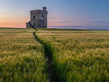Single building in a field in Waterford at sunset