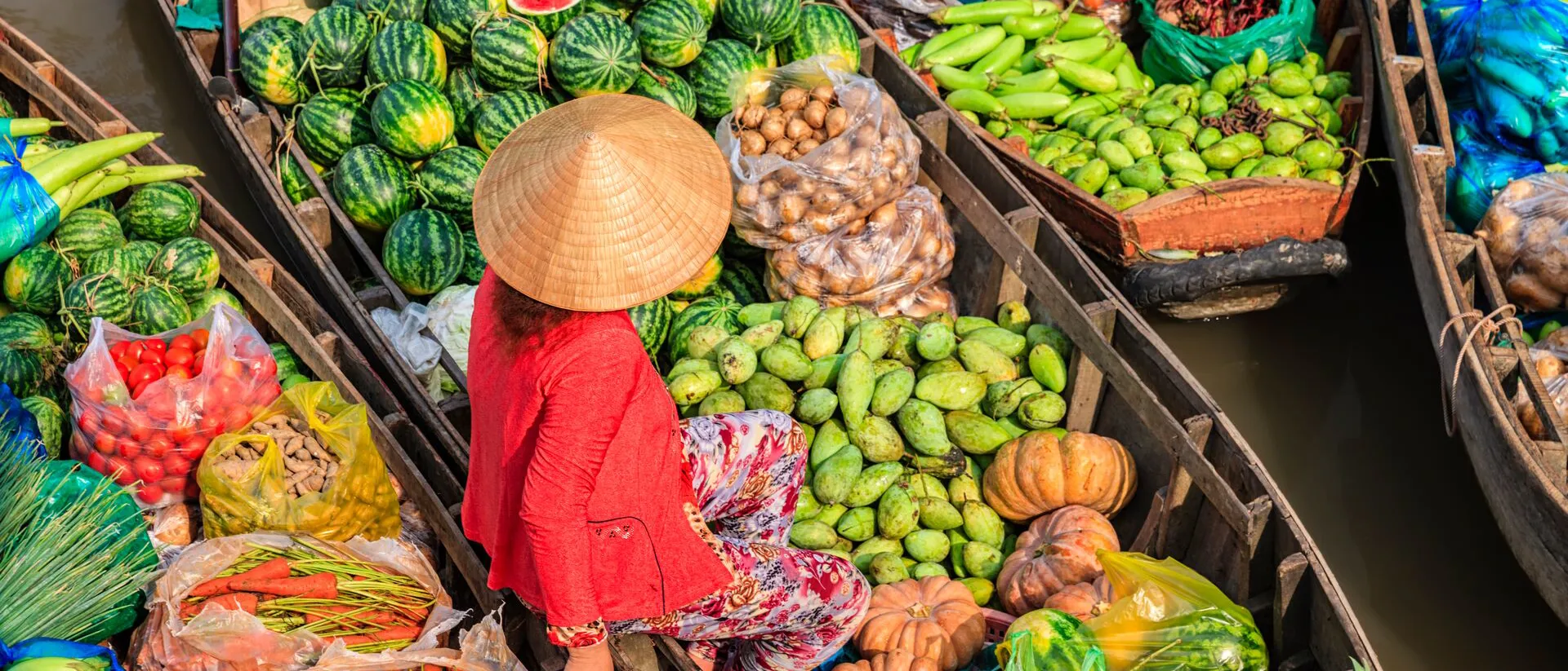 Vietnamese Woman selling fruits at a Floating Market on the Mekong River Delta in Vietnam