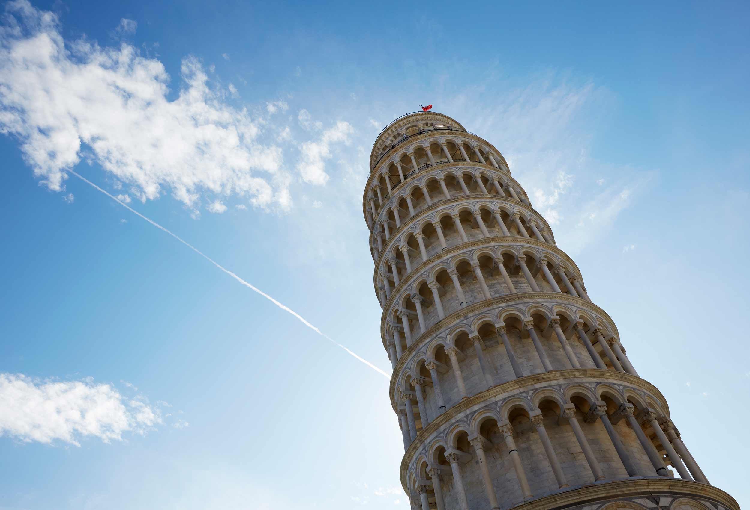 Close view of the Leaning Tower of Pisa captured from a low angle against clear blue sky in Pisa, Italy
