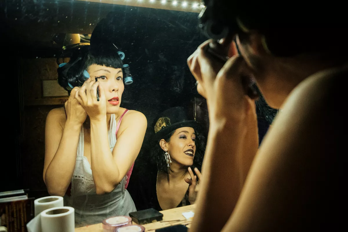 Cabaret dancers getting ready in front of a mirror in Paris, France.