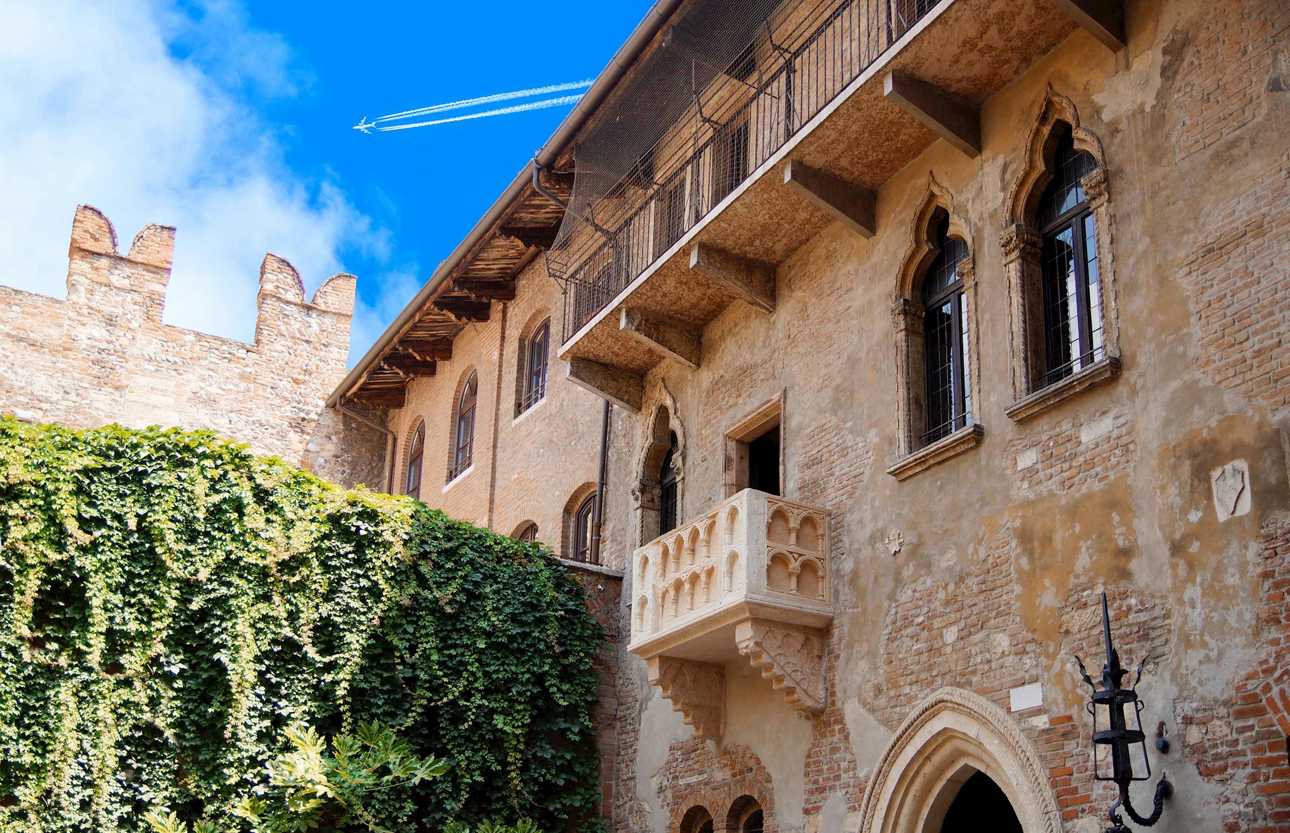 Courtyard view with stone balcony and ivy against clear sky in Verona, Italy