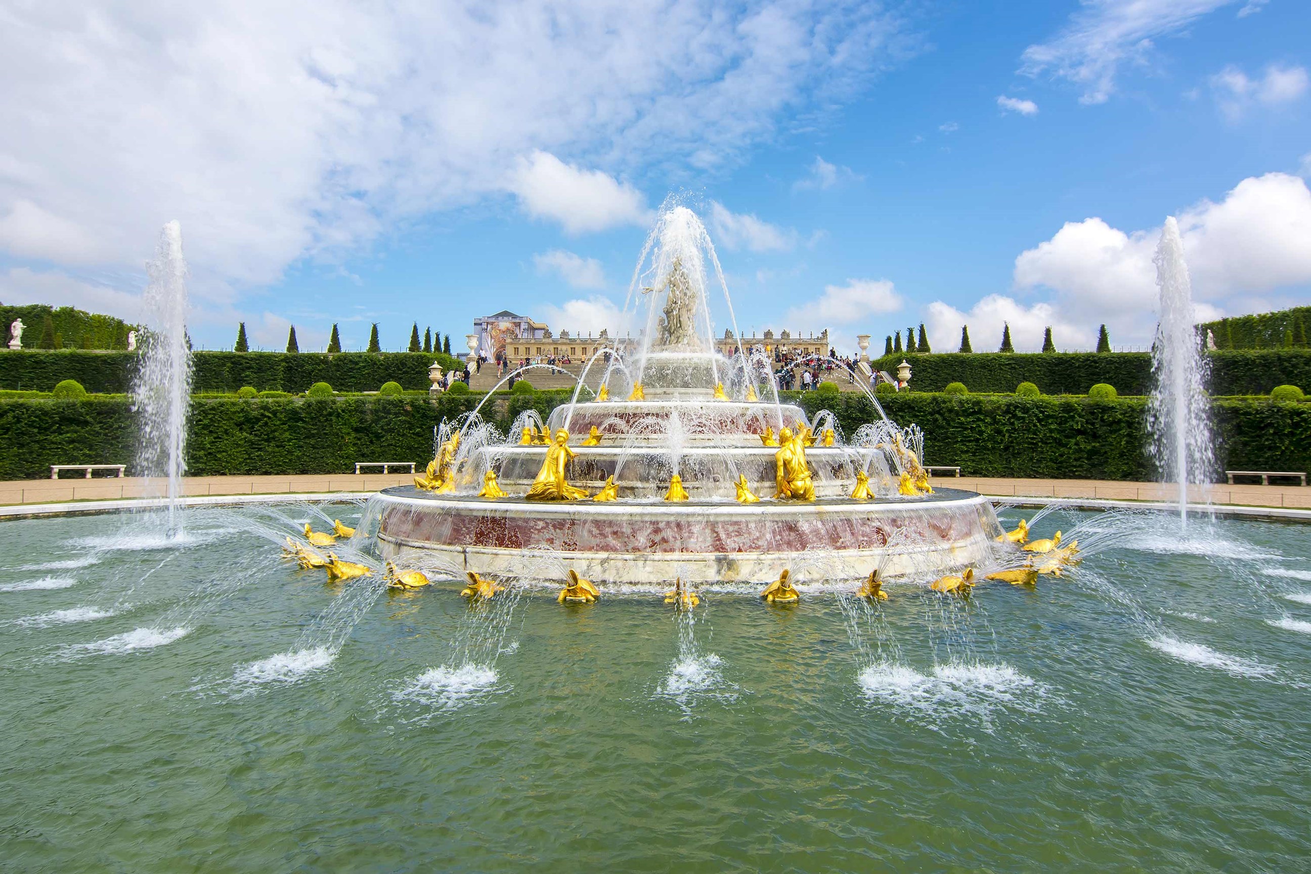 A water fountain with golden sculptures on a sunny day in Paris, France