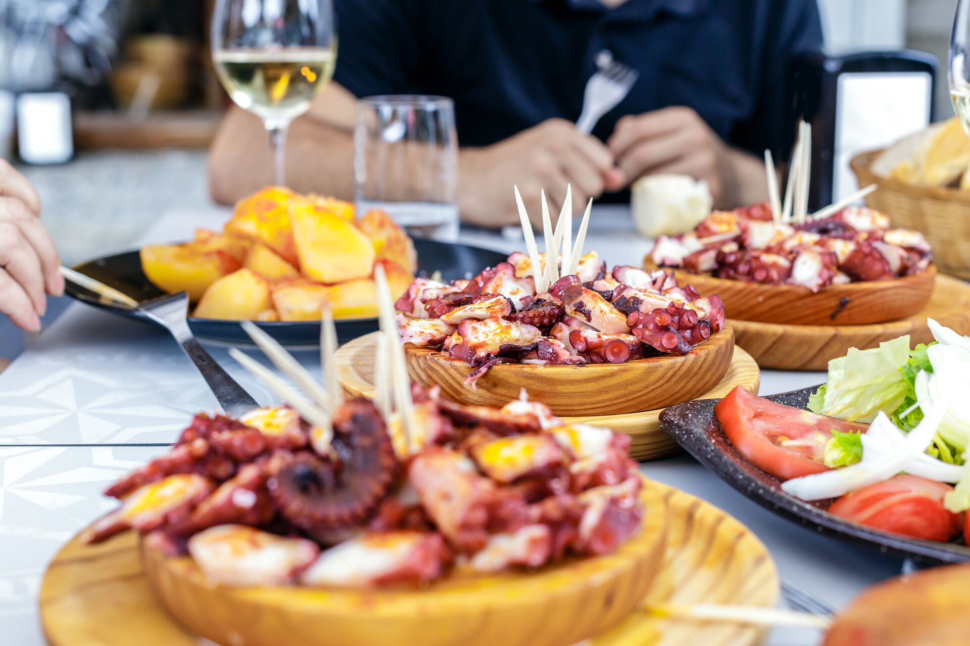 people-eating-pulpo-a-la-gallega-with-potatoes-galician-octopus-dishes-famous-dishes-from-galicia-spain-922562780.jpg