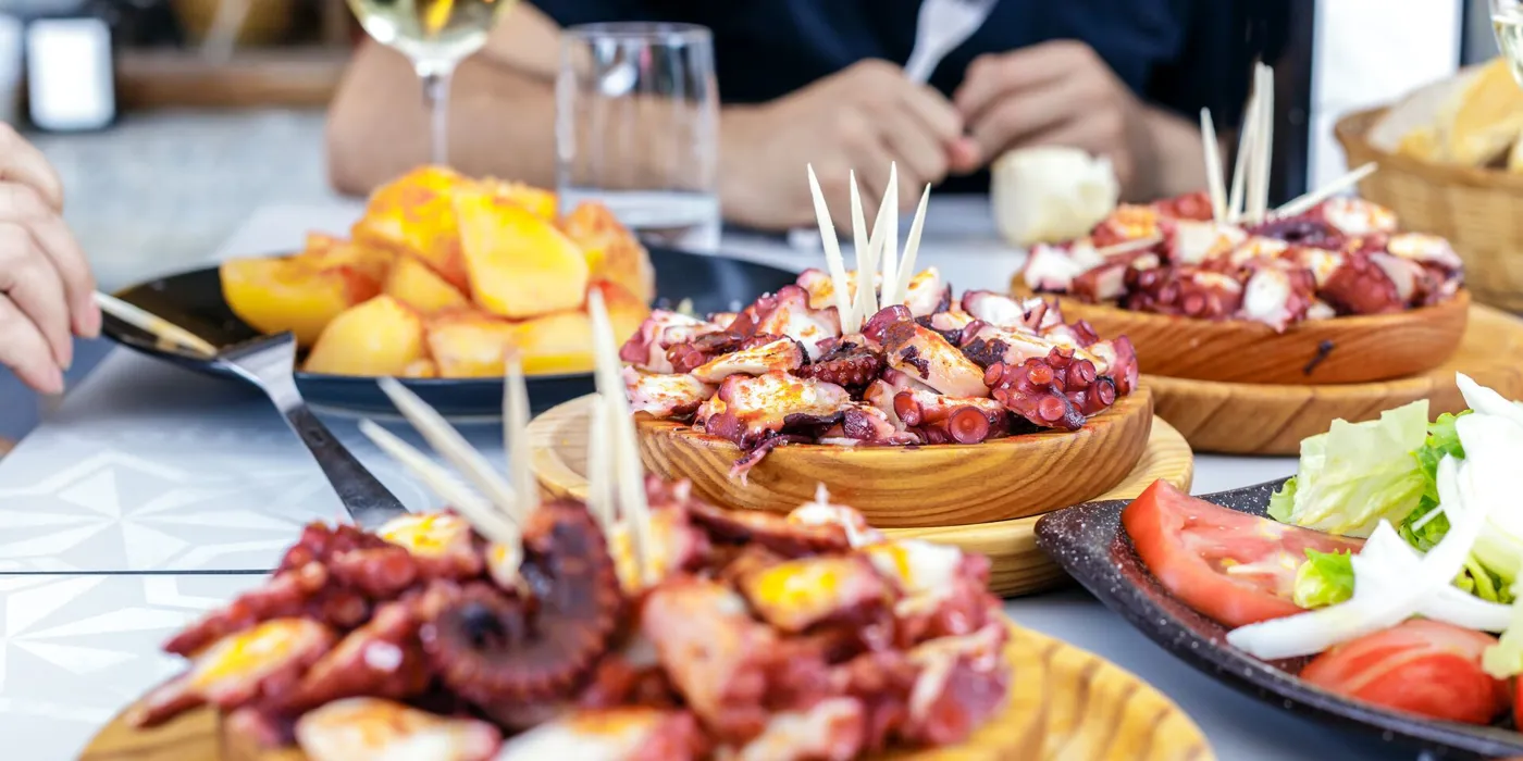 people-eating-pulpo-a-la-gallega-with-potatoes-galician-octopus-dishes-famous-dishes-from-galicia-spain-922562780.jpg