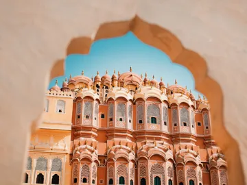 A palace framed through an intricately carved archway in Mumbai, India