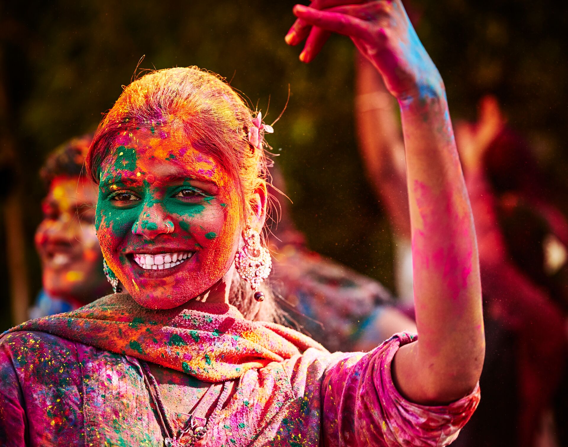 Smiling lady covered in face paint during Holi Festival