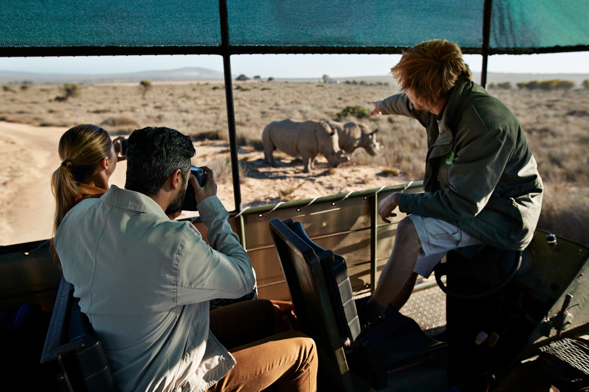 Travellers on safari watching rhino