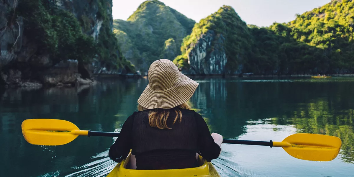 Woman kayaking across Halong Bay, Vietnam