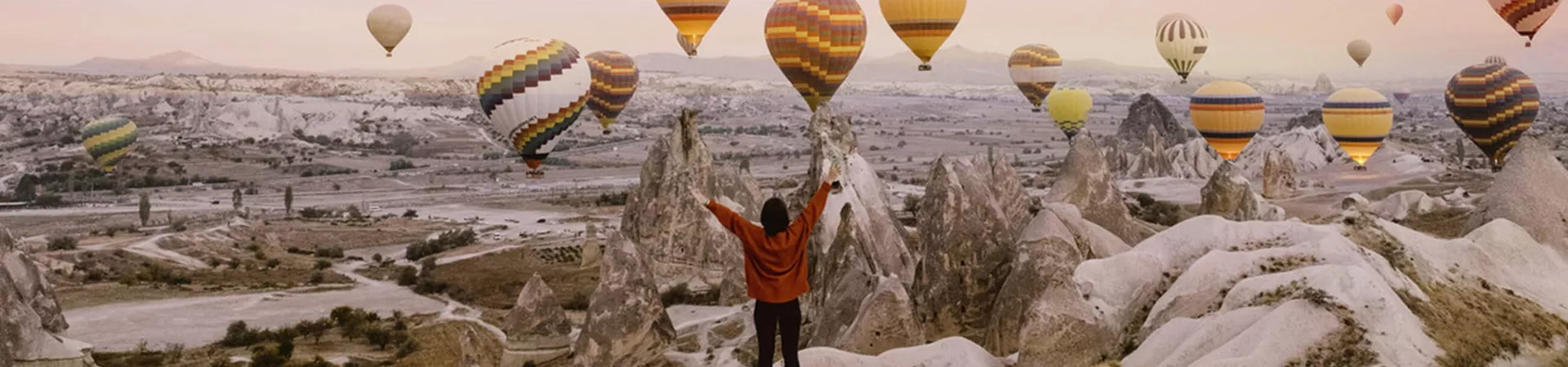 A traveller taking a photo with hot air balloons in Turkey